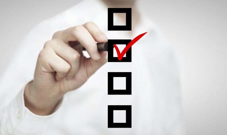 Eine Hand malt einen Haken in eine Checkbox